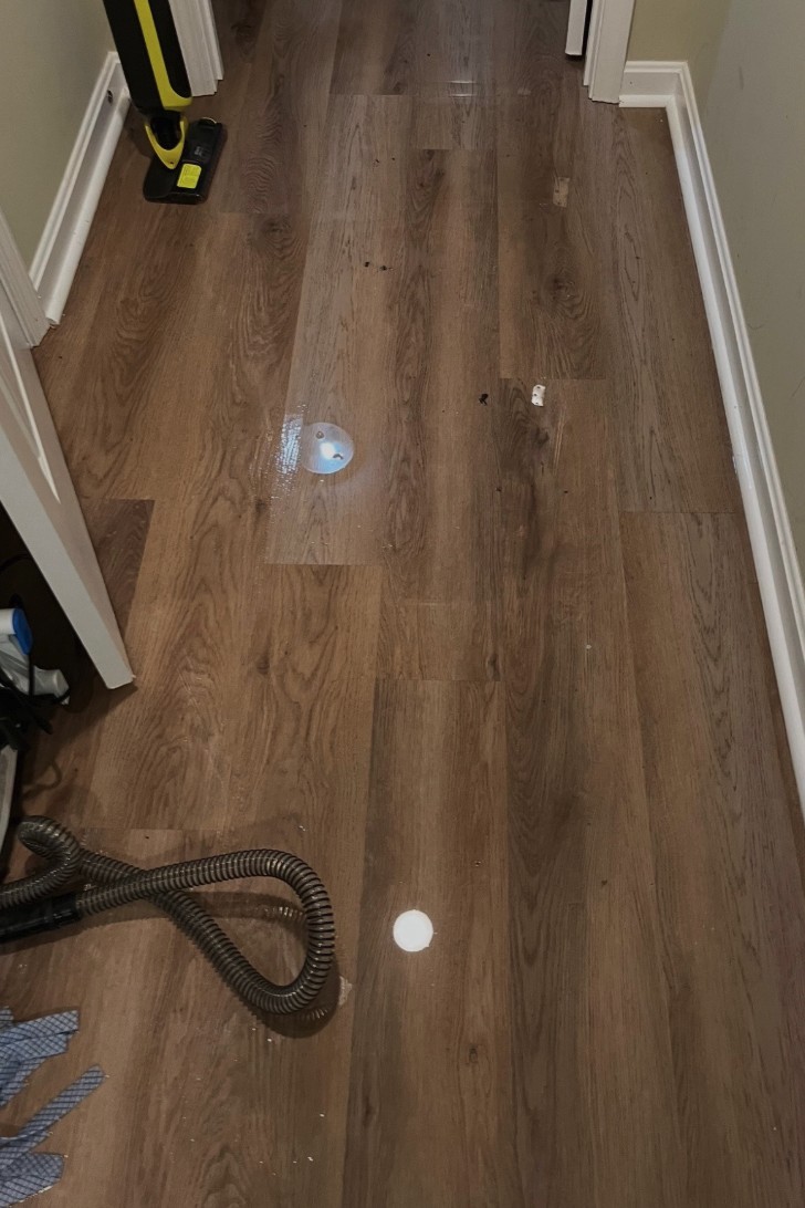 Standing water on luxury vinyl plank flooring in a Louisville basement after a burst pipe