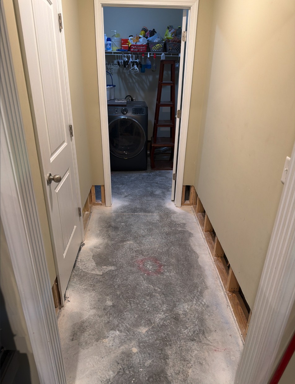 Louisville basement hallway with flooring removed and slab dried after a burst pipe cleanup