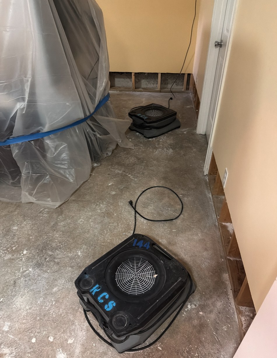 Air movers drying a stripped basement slab after Category 3 water damage in Louisville