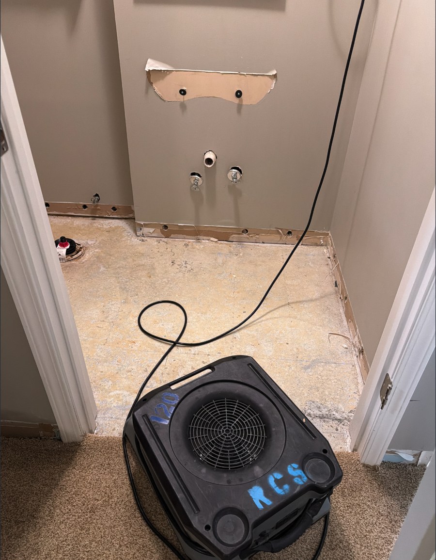 Flooring removed and an air mover drying the subfloor in a Louisville home