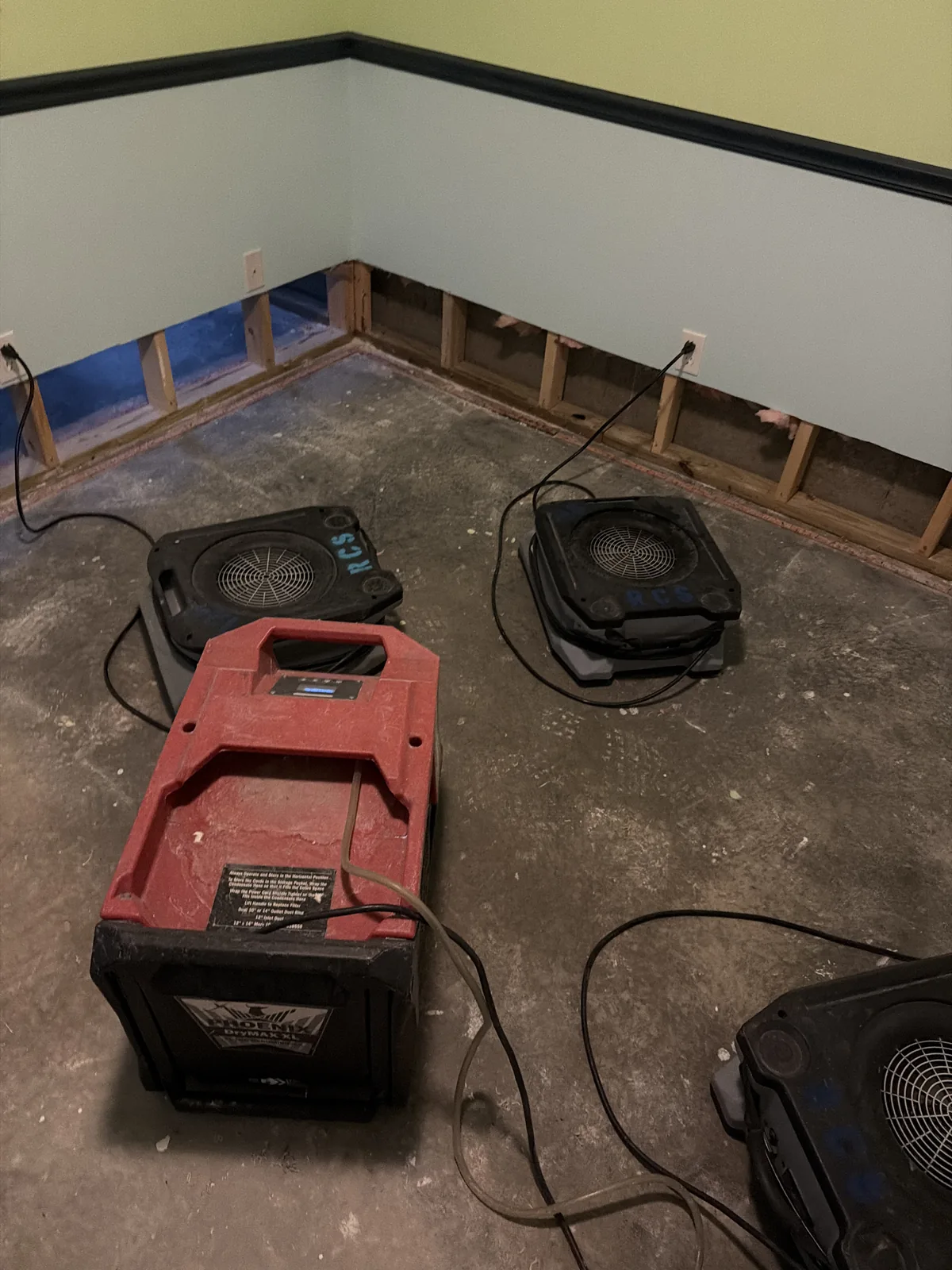 Air movers drying a flood-cut room after water damage in a Louisville home