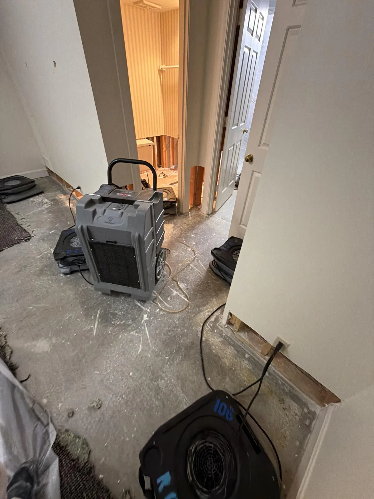 Air scrubber and air mover drying a water-damaged hallway in Louisville KY